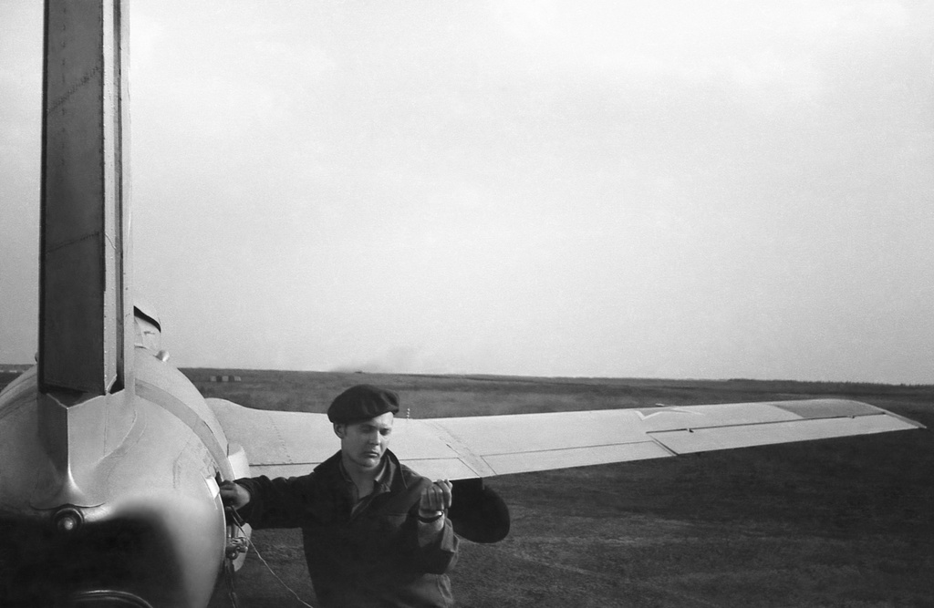 Полеты на грунтовом аэродроме в Кирсанове, 643 уап ТВВАУЛ, июнь - август 1982, Тамбовская обл., Кирсановский муниципальный округ, Голынщинский сельсовет. АОшник 1-й эскадрильи Вадим Баш (срочник) прописывает «нули» на пленке в кассете для САРПП-12.643 учебный авиаполк ТВВАУЛ (в/ч 42149, база: город Тула, аэродром Клоково, самолеты Л-29). На лето авиаполк перелетал из Тулы в Кирсанов и Новгородовку Тамбовской области (по две эскадрильи на каждый город).ТВВАУЛ – Тамбовское высшее военное авиационное училище летчиков имени М. М. Расковой.Часть расформирована в 1990 году, потом в 1995 году закрыли и Тамбовское ВВАУЛ.САРПП-12 – система автоматической регистрации параметров полета. Запись параметров ведется на фотопленку в металлической кассете. После полета кассету с записью снимали и заменяли на новую, с чистой пленкой.АОшник (сленг) – техник группы АО (авиационного оборудования), специалист, отвечающий за исправность электрических и приборных систем воздушного судна.