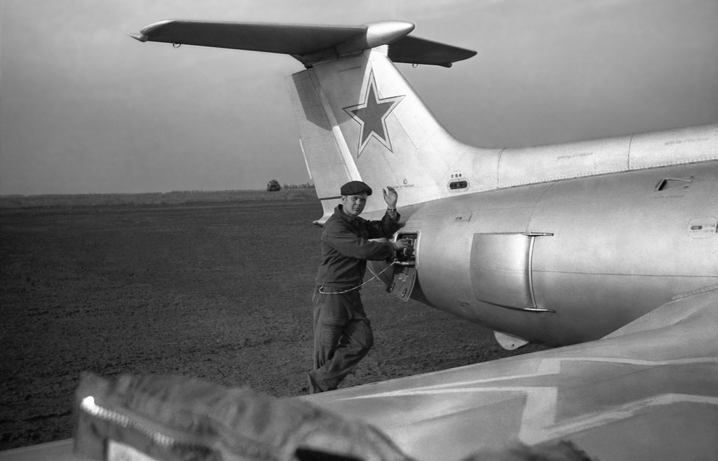 Полеты на грунтовом аэродроме в Кирсанове, 643 уап ТВВАУЛ, июнь - август 1982, Тамбовская обл., Кирсановский муниципальный округ, Голынщинский сельсовет. АОшник 1-й эскадрильи Вадим Баш (срочник) прописывает «нули» на чистой пленке в кассете для САРПП-12 перед вылетом самолета Л-29.643 учебный авиаполк ТВВАУЛ (в/ч 42149, база: город Тула, аэродром Клоково, самолеты Л-29). На лето авиаполк перелетал из Тулы в Кирсанов и Новгородовку Тамбовской области (по две эскадрильи на каждый город).ТВВАУЛ – Тамбовское высшее военное авиационное училище летчиков имени М. М. Расковой.Часть расформирована в 1990 году, потом в 1995 году закрыли и Тамбовское ВВАУЛ.САРПП-12 – система автоматической регистрации параметров полета. Запись параметров ведется на фотопленку в металлической кассете. После полета кассету с записью снимали и заменяли на новую, с чистой пленкой.АОшник (сленг) — техник группы АО (авиационного оборудования), специалист, отвечающий за исправность электрических и приборных систем воздушного судна.