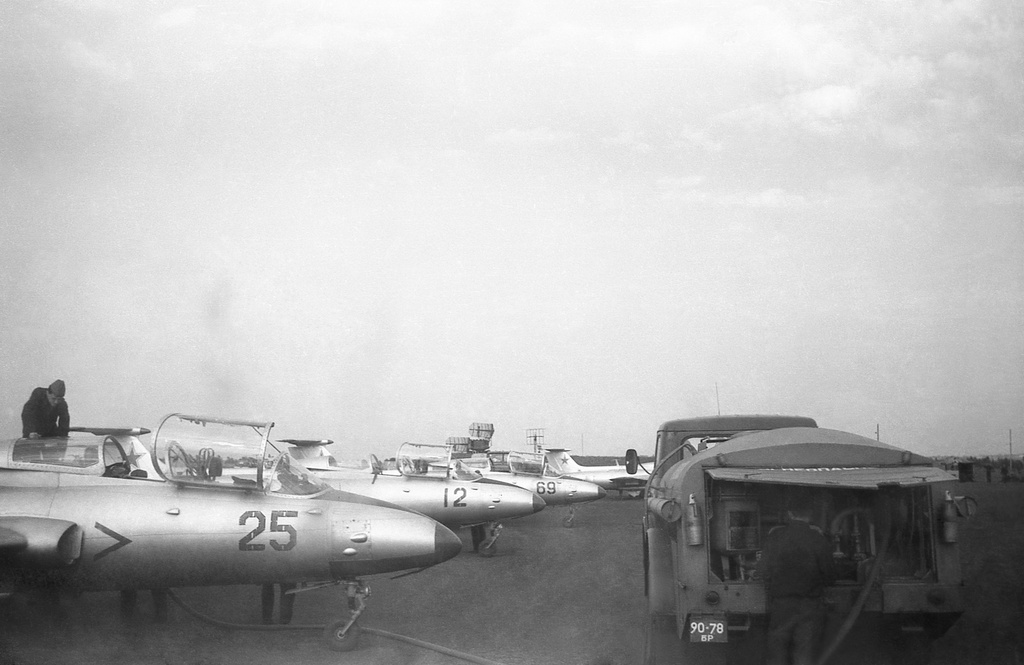 Полеты на грунтовом аэродроме в Кирсанове, 643 уап ТВВАУЛ, июнь - август 1982, Тамбовская обл., Кирсановский муниципальный округ, Голынщинский сельсовет. Самолеты Л-29 двух эскадрилий полка на грунтовой стоянке, справа – авиационный топливозаправщик ТЗ-500. Позади – РЛС, слева виден столб пыли от работы двигателя одного из бортов.643 учебный авиаполк ТВВАУЛ (в/ч 42149, база: город Тула, аэродром Клоково, самолеты Л-29). На лето авиаполк перелетал из Тулы в Кирсанов и Новгородовку Тамбовской области (по две эскадрильи на каждый город).ТВВАУЛ – Тамбовское высшее военное авиационное училище летчиков имени М. М. Расковой.Часть расформирована в 1990 году, потом в 1995 году закрыли и Тамбовское ВВАУЛ.