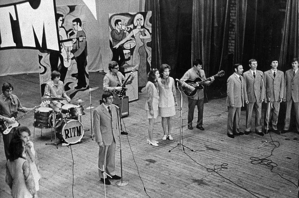 ДК Станкозавода. На сцене ВИА «Ритм», 1975 год, Рязанская обл., г. Рязань. Руководитель ансамбля Виктор Мартынкин. Состав на 1 января 1975 года: Нина Белова – вокал, Анатолий Чечулин – вокал, Евгений Ахматов – вокал, Галина Комарова – вокал, Сергей Моисеев – ритм-гитара, Владимир Амелькин – соло-гитара, Лидия Царева - вокал, Лариса Левакова – вокал , Юрий Саратовский – ударные, Михаил Коробков – бас гитара, Александр Фетисов – вокал.