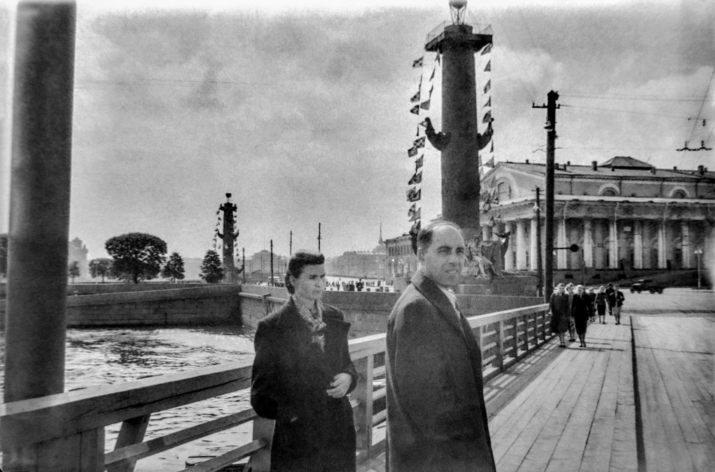 На Биржевом мосту, 1 - 28 июля 1956, г. Ленинград. Слева направо: Иванова Клавдия Федоровна и Михаил Трофимович Кретинин. На фоне вида с Биржевого моста на Стрелку Васильевского острова, Ростральные колонны и Центральный военно-морской музей.Пленка N 010 кадр 01 © Г. В. Иванов