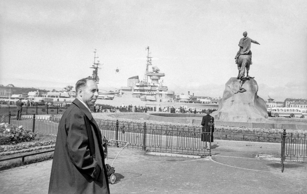 Прогулка у памятника, 1 - 28 июля 1956, г. Ленинград. Михаил Трофимович Кретинин у памятника Петру I. На Заднем плане крейсер «Жданов». 29 июля 1956 года этот крейсер (бортовой № 20) участвовал в параде по случаю ДНЯ ВМФ в качестве флагманского корабля на Неве.Пленка № 010, кадр 07 © Г. В. Иванов.