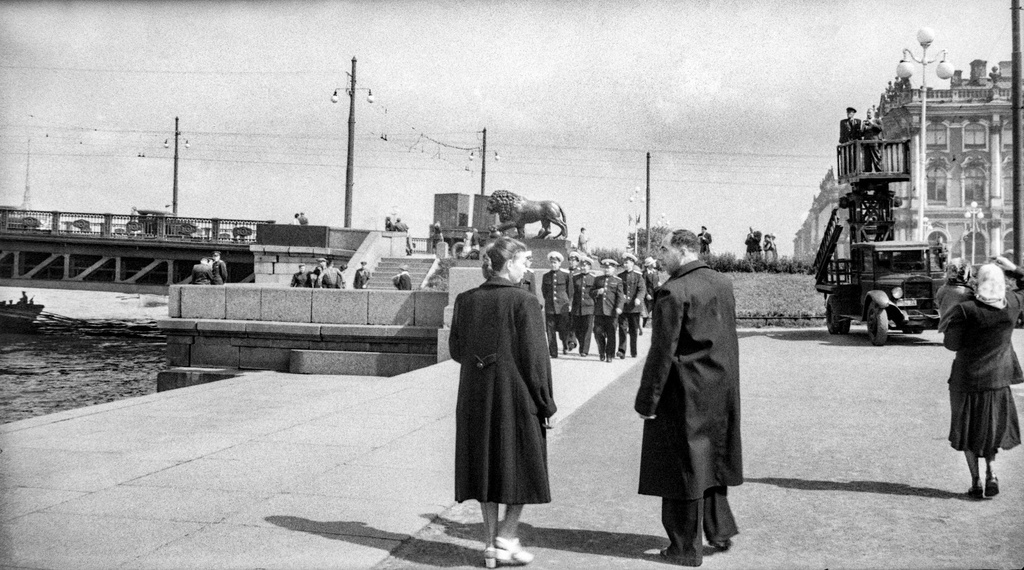Прогулка по набережной, 1 - 28 июля 1956, г. Ленинград. Клавдия Федоровна Иванова и Михаил Трофимович Кретинин у Дворцового моста. В правой части кадра автовышка шахтного типа на базе ЗИС-5 с механическим приводом от шасси. На вышке фотокорреспондент в сопровождении сотрудника силовых органов.Пленка № 010, кадр 13 © Г. В. Иванов.