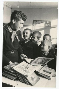 Пионер и октябрята в школьной библиотеке, 1947 год. Лозунг на стене: «Да здравствует XXX годовщина Октября!»Выставка «Октябрята» с этой фотографией.