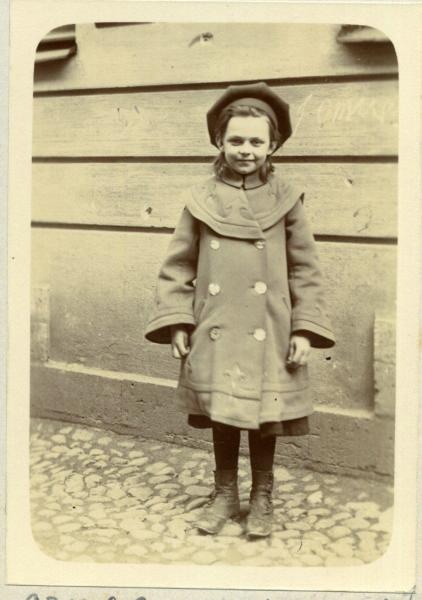 Девочка в рост на фоне деревянной стены, 1906 год
