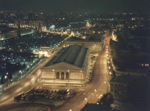 Московский Манеж, 1984 год, г. Москва. Манеж был построен в 1817 году по проекту Августина Бетанкура в честь пятилетия победы в Отечественной войне 1812 года. В 1824–1825 годах Осип Бове оформил фасады манежа в стиле ампир. Первоначально Манеж назывался Экзерциргауз и предназначался для строевой подготовки войск.&nbsp;С 1831 года в здании стали проводиться выставки и народные гуляния, еще позднее – концерты и балы. После революции большевики устроили в его помещениях казарму, затем – гараж правительственных автомобилей. В 1957 году учреждению был присвоен статус Центрального выставочного зала, в нем регулярно стали проводиться выставки и другие публичные мероприятия.В 2004 году здание сильно пострадало от пожара и было перестроено по проекту архитектора Павла Андреева.&nbsp;В 1990 году площади возвращено название Манежная.В 1980–1990-е городская иллюминация превратилась в отдельную индустрию, без нее не обходилось ни одно событие. Для светового дизайна  стали привлекаться лучшие художники, архитекторы, инженеры. В дни праздников на улицах городе разыгрывались целые световые спектакли.&nbsp;Выставки&nbsp;«Пустые улицы двух столиц», «Центральный Манеж» с этой фотографией.