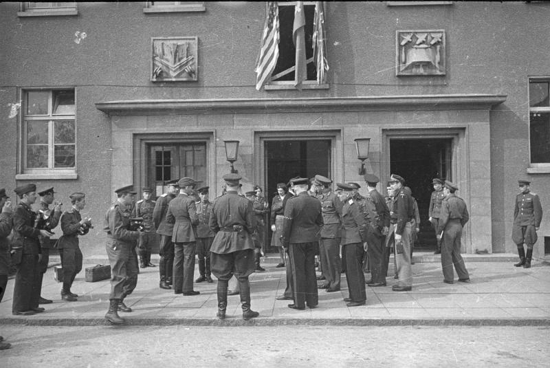 Военные, стоящие у входа в здание с флагами на фасаде, 1945 год, Германия, г. Берлин, Карлсхорст