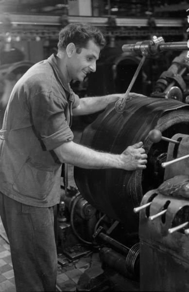 На шинном заводе, 1955 - 1965, Армянская ССР, Ереван. Работник отделяет куски резины специальным резаком.