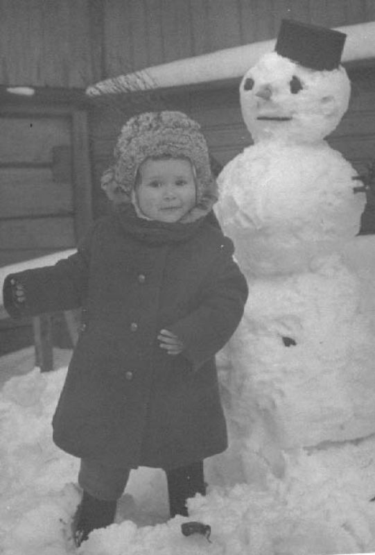 Снеговик, 1970-е, Вологодская обл., Череповецкий р-н. Маша Ахутина во дворе своего дома.Выставка «Снеговик, снеговик, жить на холоде привык» с этой фотографией.