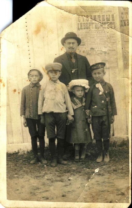Дедушка с детьми у забора с афишей., 1916 год, Владимирская губ., г. Муром. Из архива семьи Свердловых.