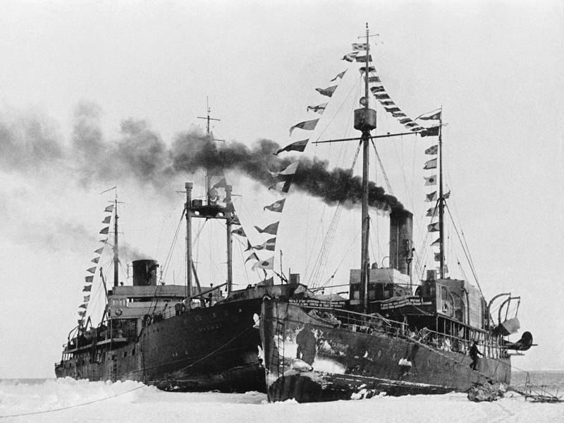 Ледокольные пароходы «Мурман» и «Таймыр» у льдины станции «Северный полюс-1». Гренландское море, 19 февраля 1938. Высадка экспедиции на лед была выполнена 21 мая 1937 года. Официальное открытие дрейфующей станции «Северный полюс-1» состоялось 6 июня 1937 года. Через 9 месяцев дрейфа (274 дня) на юг станция была вынесена в Гренландское море, льдина проплыла более 2000 км. Ледокольные пароходы «Таймыр» и «Мурман» сняли полярников 19 февраля 1938 года.Видео&nbsp;«Северный полюс-1» и «Гениальный радист и "дедушка советского радиолюбительства" Эрнст Кренкель» с этой фотографией.