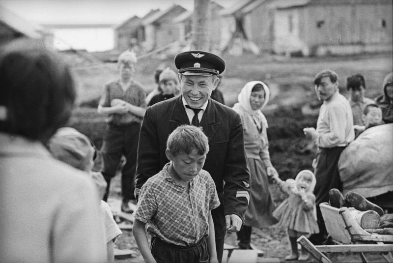Летчик-ненец среди местных жителей, 1965 год, Архангельская обл., Ненецкий НО, г. Нарьян-Мар. Из серии «Край земли. Ненцы».В 1977 году Ненецкий национальный округ был переименован в Ненецкий автономный округ. 