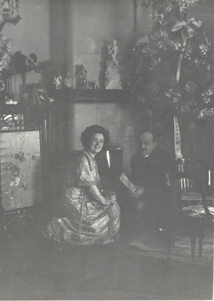 Портрет мужчины и женщины в гостиной перед камином, 1910-е. На камине скульптура Марка Матвеевича Антокольского «Мефистофель».