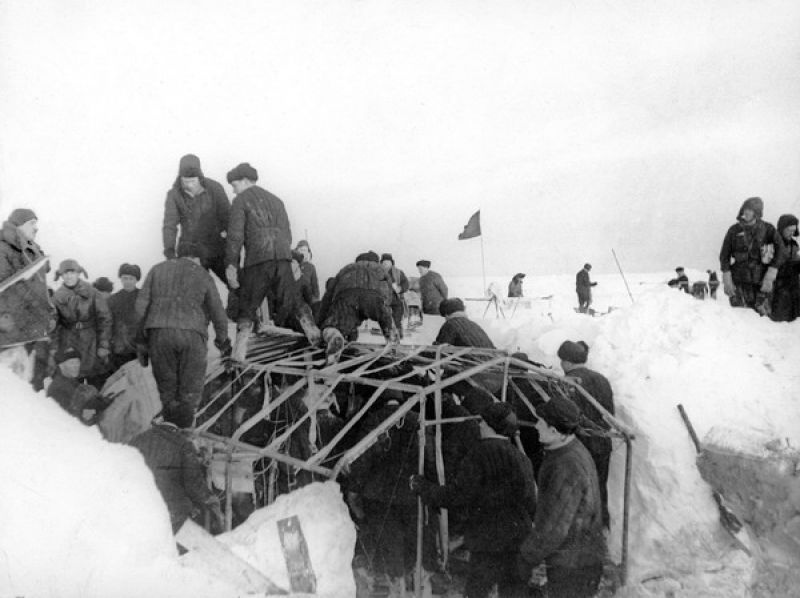 Участники экспедиции по эвакуации станции «Северный Полюс» помогают разбирать жилую палатку, февраль 1938
