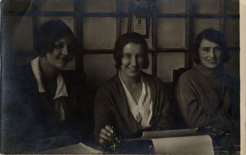 Три молодых женщины за письменным столом, 8 октября 1925, Владимирская губ., г. Муром. В центре – Варвара Бычкова. Бюро НОТ (Научная организация труда).Выставка «Главное орудие слова в ХХ веке» с этой фотографией.