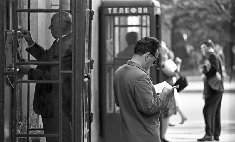 У телефонной будки, 1960-е, г. Ленинград. Выставка «Самая читающая страна в объективе Всеволода Тарасевича» с этой фотографией.