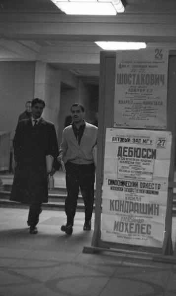 В фойе, у афиши, 1963 - 1964, г. Москва. Выставка «Афиши XX века» с этим снимком.