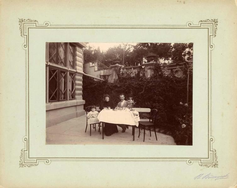 Семья во дворе дома за столом, 1900-е