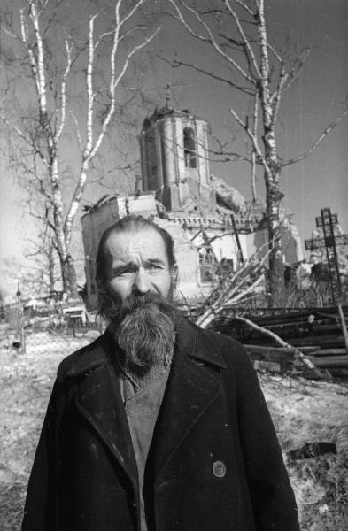 Мужчина на фоне полуразрушенной церкви, 1943 год, Смоленская обл., Гжатск. Ныне город Гагарин.