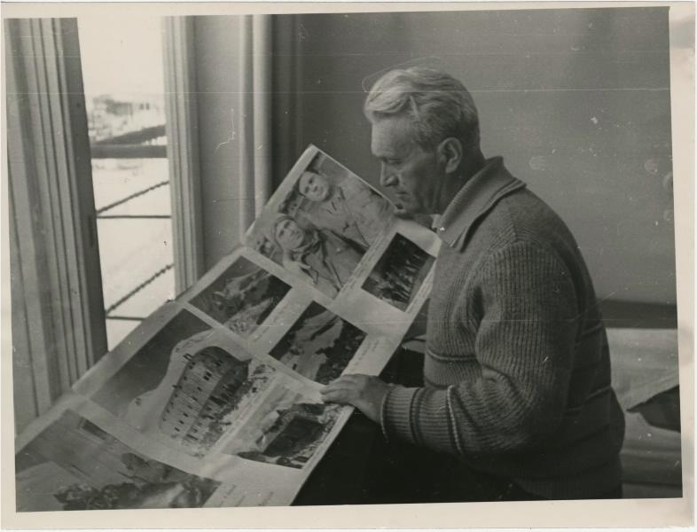 Мужчина рассматривает фотографии, 1950-е