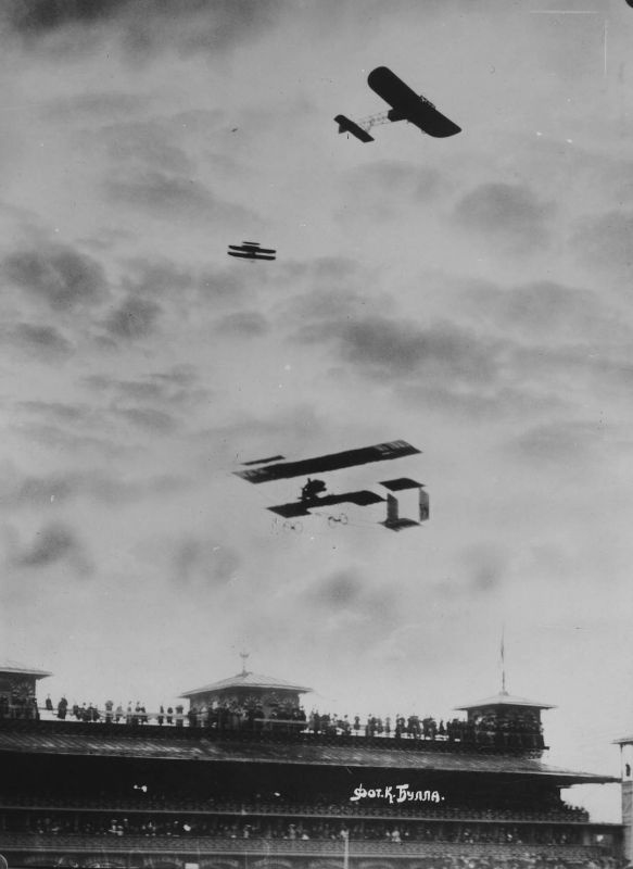 Члены аэроклуба наблюдают за полетом самолетов «Райт», «Фарман» и «Блерио» (на «Райте» - авиатор Н.Е. Попов), 25 апреля 1910 - 3 мая 1910, г. Санкт-Петербург. Выставка «Карл Булла» с этой фотографией.