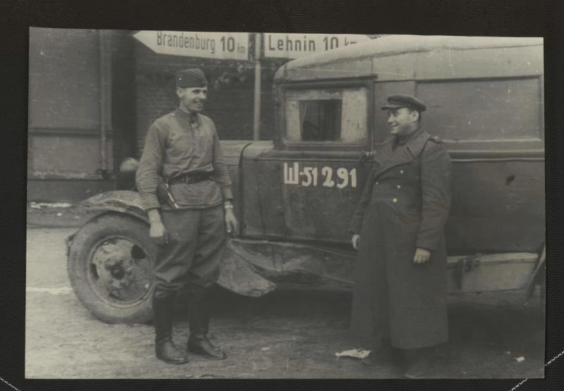 Два советских бойца, позирующие на фоне автомобиля и географического указателя, 5 - 31 мая 1945, Германия