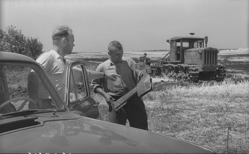Механизаторы во время полевых работ, 1960-е. На втором плане - трактор ДТ-54.