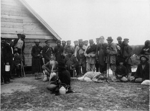 Крестьяне стоя, сидя или лежа расположились на отдых возле деревянного строения, июль 1903, Нижегородская губ.