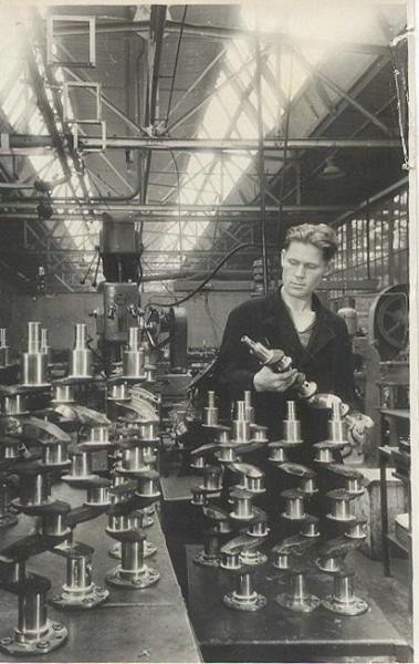 Слесарь С. М. Усцов просматривает продукцию, изготовленную им сверх плана, 22 сентября 1953, г. Москва