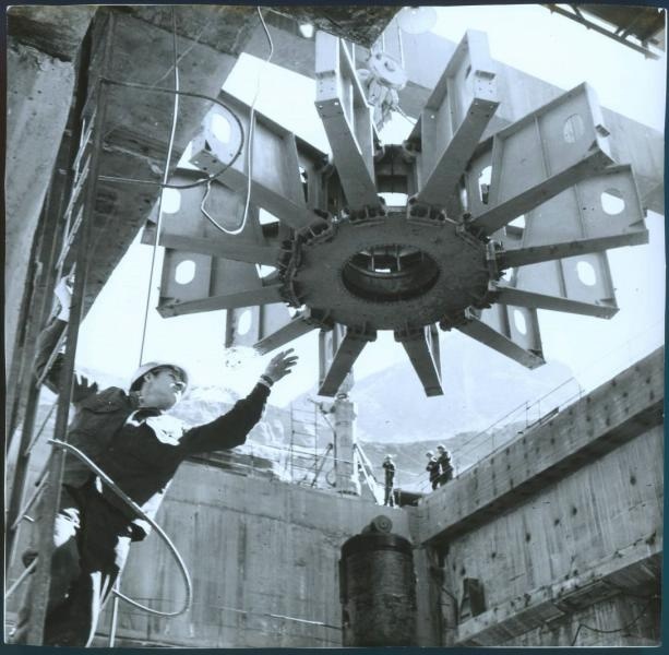 На стройке, 1950-е, Украинская ССР, Новая Каховка. Рабочий на лестнице, руководит процессом монтажа части гидроагрегата.