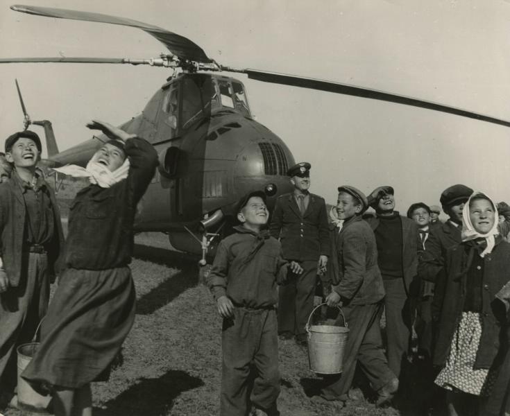 «Еще один летит!», 1960 год, Украинская ССР, Черновицкая обл.. Люди стоят на фоне вертолета МИ-4, который являлся первым военно-транспортным вертолетом вооруженных сил СССР.