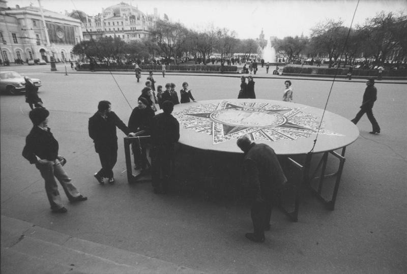 Без названия, 1985 год, г. Москва. На площадке перед Большим театром группа рабочих готовит инсталляцию в виде ордена Победы, чтобы поднять фасад.