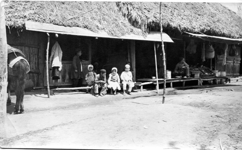 Дети на фоне постройки под соломенной крышей, 1910-е