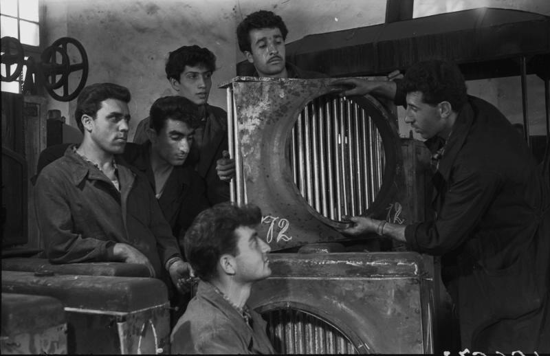 В цеху компрессорного завода, 1955 - 1965, Армянская ССР, Ереван. Группа молодых людей рассматривает большую деталь с решеткой по центру, в цеху компрессорного завода.