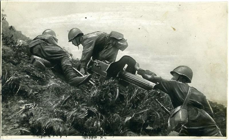 На тактических занятиях пулеметчики-красноармейцы Рощупкин, Заминов и Николаев втаскивают пулемет на сопку, 1944 год