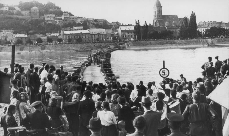 Жители Венгрии ждут, когда советские саперы закончат понтонный мост через Дунай, чтобы переправиться на другой берег, май - июнь 1945, Венгрия, г. Будапешт. Мост через Дунай в Будапеште, существовавший с 1945 по 1960 год и соединявший площадь Баттяни в Буде с площадью Лайоша Кошута в Пеште.